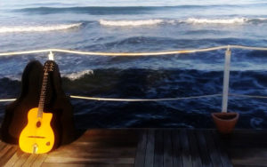 chitarra sul pontile con sfondo mare